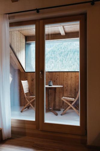 a room with a sliding glass door with a table and chairs at Alpine Chalet Sauter in San Vigilio Di Marebbe