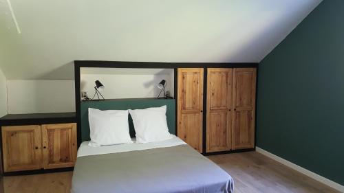 1 dormitorio con 1 cama y armarios de madera en La Grange du Héron, en Balaguier-dʼOlt