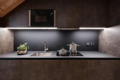 a kitchen with a sink and a microwave at Alpine Chalet Sauter in San Vigilio Di Marebbe