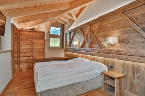 - une chambre dans une cabane en rondins avec un lit et une fenêtre dans l'établissement Garni Maso San Michele, à Cavalese