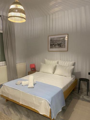 a bedroom with a large white bed with a chandelier at Thrace Village - LUXURY APARTMENTS XANTHI (LAX) in Kimméria
