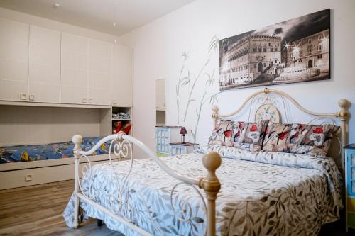 トゥオーロ・スル・トラジメーノにあるLa Poventaの白いベッドと壁に絵画が飾られたベッドルーム1室