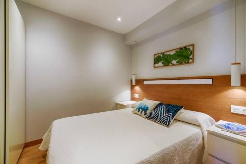ein Schlafzimmer mit einem großen weißen Bett in einem Zimmer in der Unterkunft Orzan Beach 2 by TheBlueWaveApartments com in A Coruña