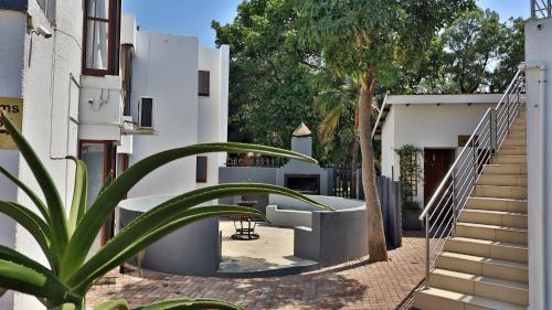 a stairway leading to a building with a tree at Khayalami Hotel - Mbombela in Nelspruit