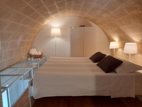 Al Duomo Relais في ماتيرا: غرفة نوم بسرير كبير في جدار حجري