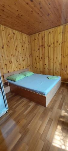 Cama en habitación de madera con suelo de madera en Holiday Home at Fedkovycha St. en Kiev