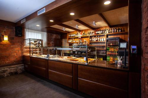 a restaurant with a counter with food and drinks at Hotel Cēsis in Cēsis