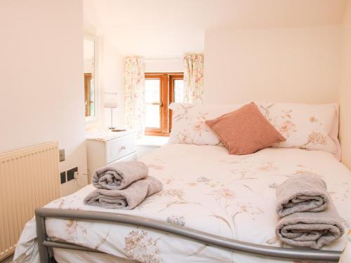 a bedroom with a bed with towels on it at Linley Lane Cottage in Bishops Castle