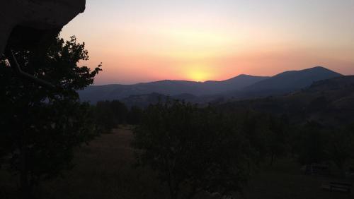 a sunset over a mountain range with the sun setting at Kućica za odmor-Borova glava in Zlatibor