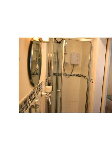 a bathroom with a shower and a mirror at Ashlea Guest House in Banbury
