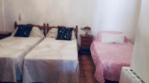 2 camas en una habitación pequeña con ermottermottermott en Casa centro Enguidanos, en Enguídanos