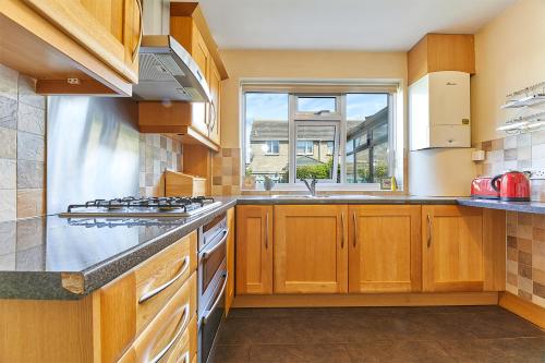 a large kitchen with wooden cabinets and a window at Host & Stay - Shorty's in Amble