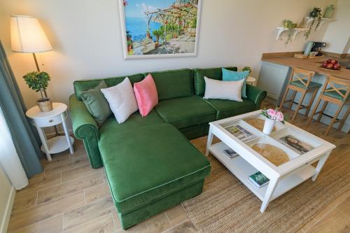 a living room with a green couch and a table at A'MORE Apartment in St. St. Constantine and Helena