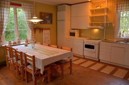 Lillstugan, södra Bergslagen في Surahammar: مطبخ فيه طاولة وكراسي كبيرة