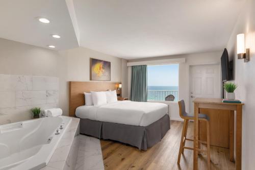 a hotel room with a bed and a bath tub at Radisson Beachfront Hotel - Panama City Beach in Panama City Beach
