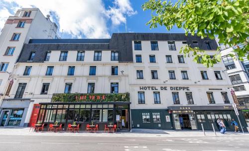 un grande edificio bianco con sedie rosse su una strada di Best Western Plus Hotel de Dieppe 1880 a Rouen