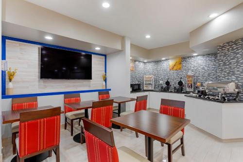 a restaurant with tables and chairs and a kitchen at Comfort Inn & Suites Memphis East in Memphis