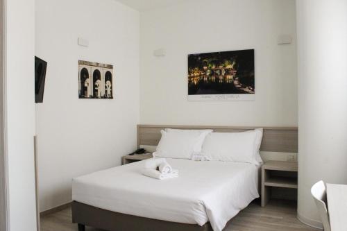 a bedroom with a white bed with a towel on it at Best Quality Hotel Politecnico in Turin