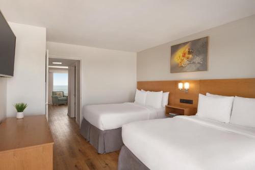 a hotel room with two beds and a television at Radisson Beachfront Hotel - Panama City Beach in Panama City Beach