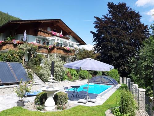 una casa con sombrilla y piscina en Ferienwohnung Anna Zechner, en Flattach