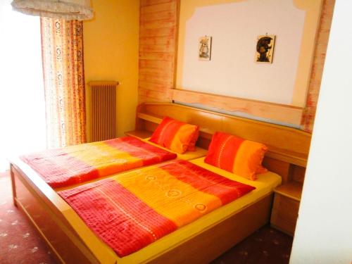 a bedroom with two beds with colorful blankets at Pension Susi in Wagrain