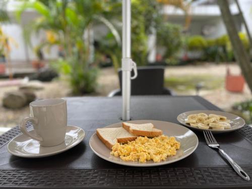 a table with two plates of food and a cup of coffee at Hotel Luna Roja del Llano in Yopal