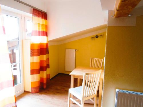 a dining room with a table and chairs and a window at Pension Susi in Wagrain