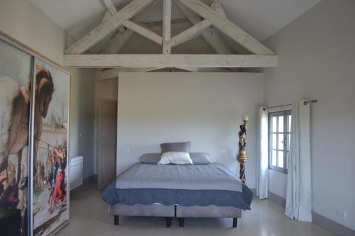a bedroom with a bed and a wooden ceiling at domaine Les Castans in Saint-Thibéry