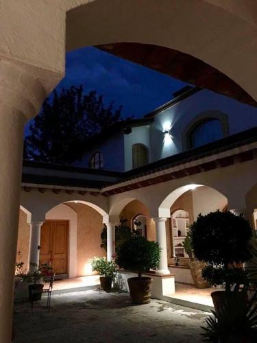 a building with an archway in a courtyard at night at La Casona de los Colibríes in Villa del Pueblito