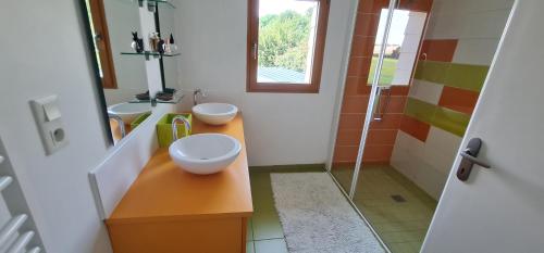 a bathroom with two sinks and a glass shower at chambres tout confort in Conlie