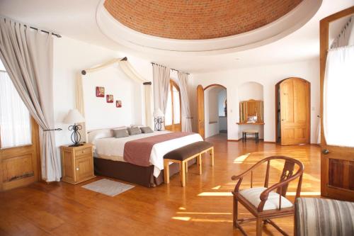 een slaapkamer met een bed en een tafel en stoelen bij La Casona de los Colibríes in Villa del Pueblito
