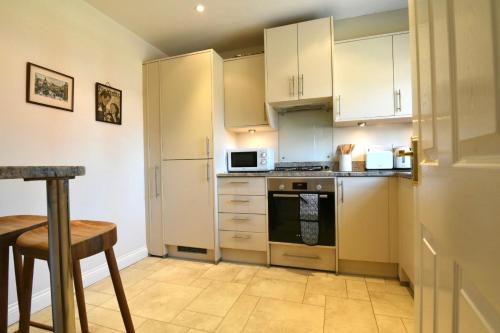 a kitchen with white cabinets and a stove top oven at Whole house, easy walk to town centre, Parking, Self Catering, Great View, 3 bedrooms, sleeps 6 in Stratford-upon-Avon