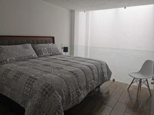a bedroom with a bed and a chair at Loft Estancia Real in Morelia