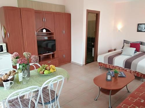 a hotel room with a bed and a table with fruit on it at Yellow Apartmanház in Bük