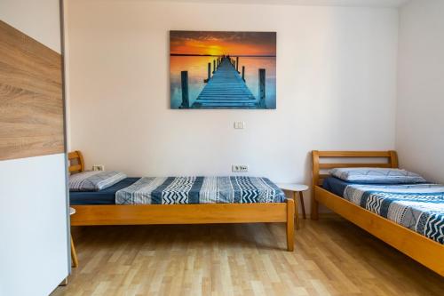 dwa łóżka w pokoju z obrazem na ścianie w obiekcie Sunny Old Town Apartment w Koprze