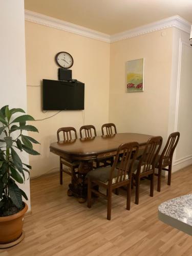 a dining room table with chairs and a clock on the wall at Rest house Jermuk in Jermuk
