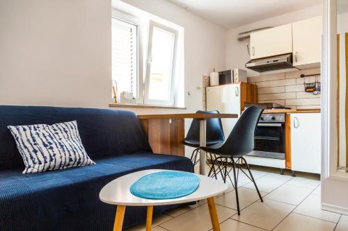 a living room with a blue couch and a table at Sunny Old Town Apartment in Koper