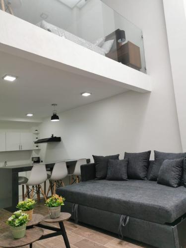 a living room with a gray couch and a table at Loft Estancia Real in Morelia