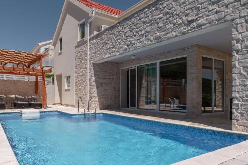 a swimming pool in front of a house at Villa Anouk in Pitve