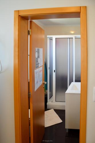 a bathroom with a glass door and a sink at Teixeira House in Arco da Calheta