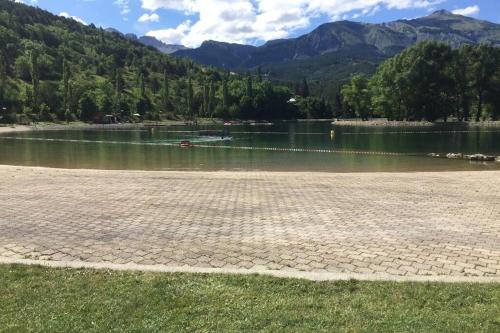 a body of water with mountains in the background at Maison neuve proche de Barcelonnette in Jausiers