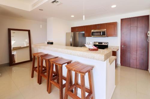 a kitchen with a counter with bar stools in it at Departamento en Gavias Grand Mazatlan 920 Torre Sur in Mazatlán