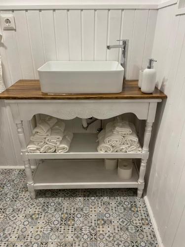 a bathroom with a sink and towels on a shelf at Cabana The Lux in Beclean