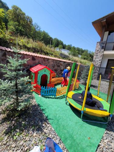 una zona de juegos para niños con un parque infantil con un juego de juegos en Konstantine's Chalet, en Bakuriani