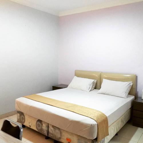 a bedroom with a large bed with white sheets at BLESSING RESIDENCE HOTEL in Jakarta