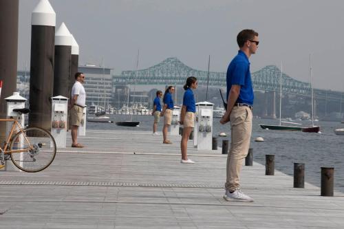 a group of people standing on a pier near the water at Boston Yacht Haven in Boston