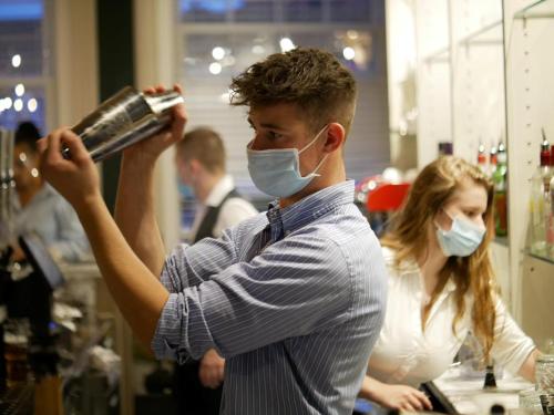 a man wearing a face mask holding a hair dryer at The Falcon Hotel in Bridgnorth