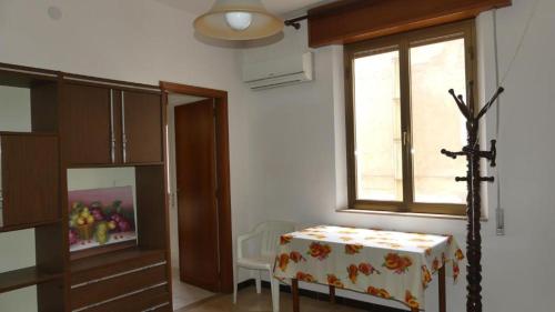 a living room with a table and a window at Appartamento fronte mare San vito lo capo in San Vito lo Capo