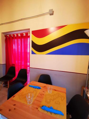a room with a table with chairs and a flag at Ostello La Salana in Capannori