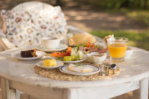 una mesa con platos de comida y un vaso de jugo de naranja en Bela Vista Hotel Boutique, en Caraíva